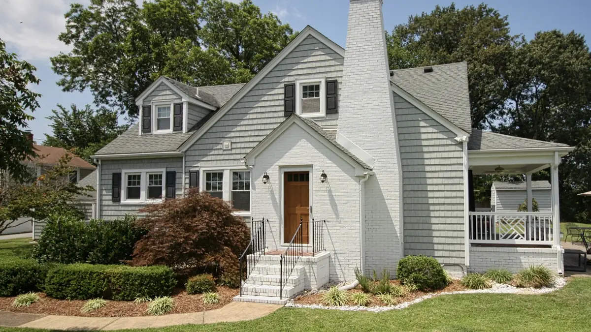 A gray house with a white chimney and a front porch on a lawn - Leak Detection in Cape Girardeau